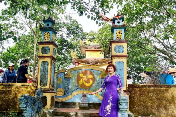 Tác giả Phạm Thị Hồng Thu bên Miếu thờ các anh hùng liệt sĩ ở Động Ông Do Hải Lăng, Quảng Trị