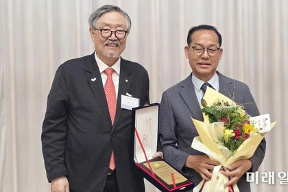 Nhà thơ Kim Yoo-je nhận bằng khen và hoa chúc mừng từ Chủ tịch Hiệp hội nhà văn Hàn Quốc (Kim Ho-woon) tại lễ trao giải.
