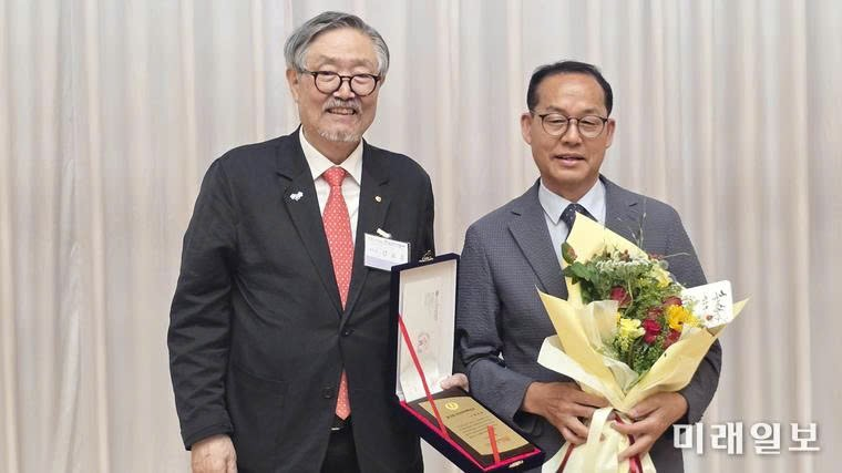 Nhà thơ Kim Yoo-je nhận bằng khen và hoa chúc mừng từ Chủ tịch Hiệp hội nhà văn Hàn Quốc (Kim Ho-woon) tại lễ trao giải.